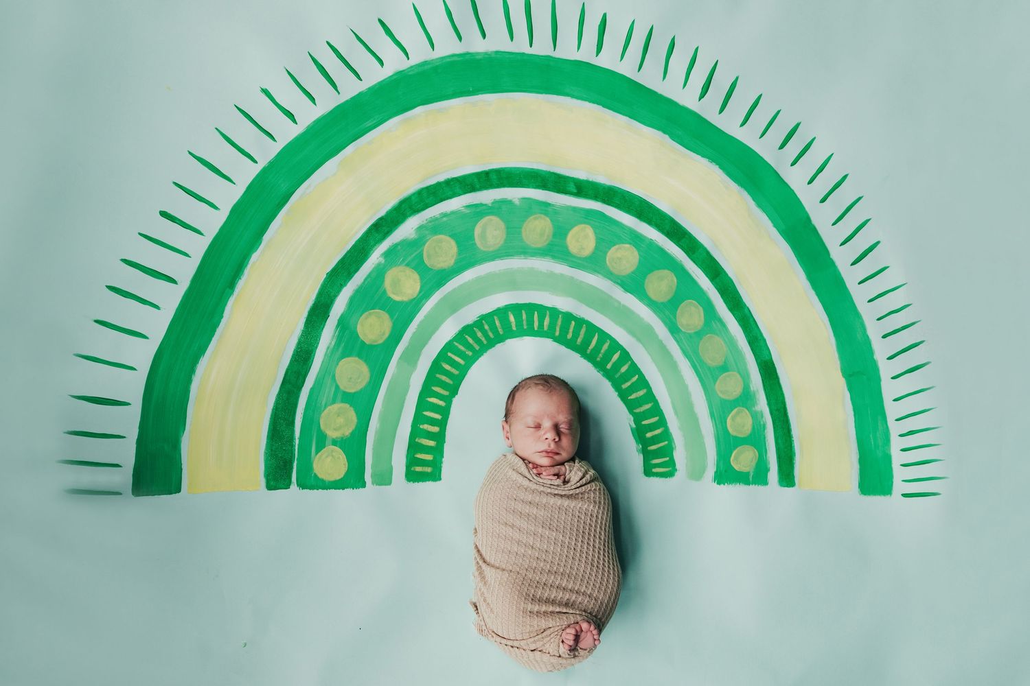 Progressive series showing baby milestones with green rainbow design backdrop.