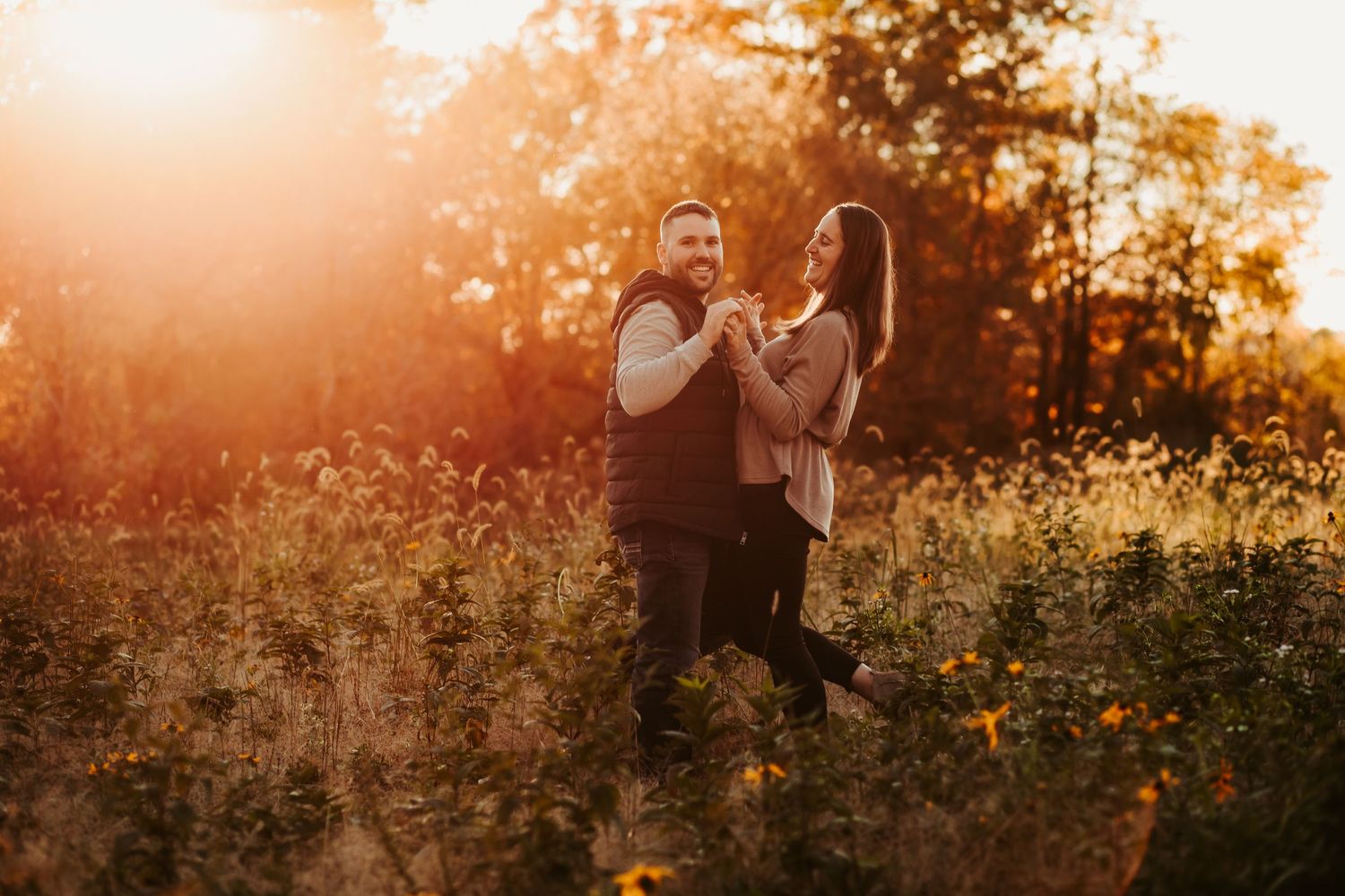 Family silhouettes walking through wildflowers at golden hour.
