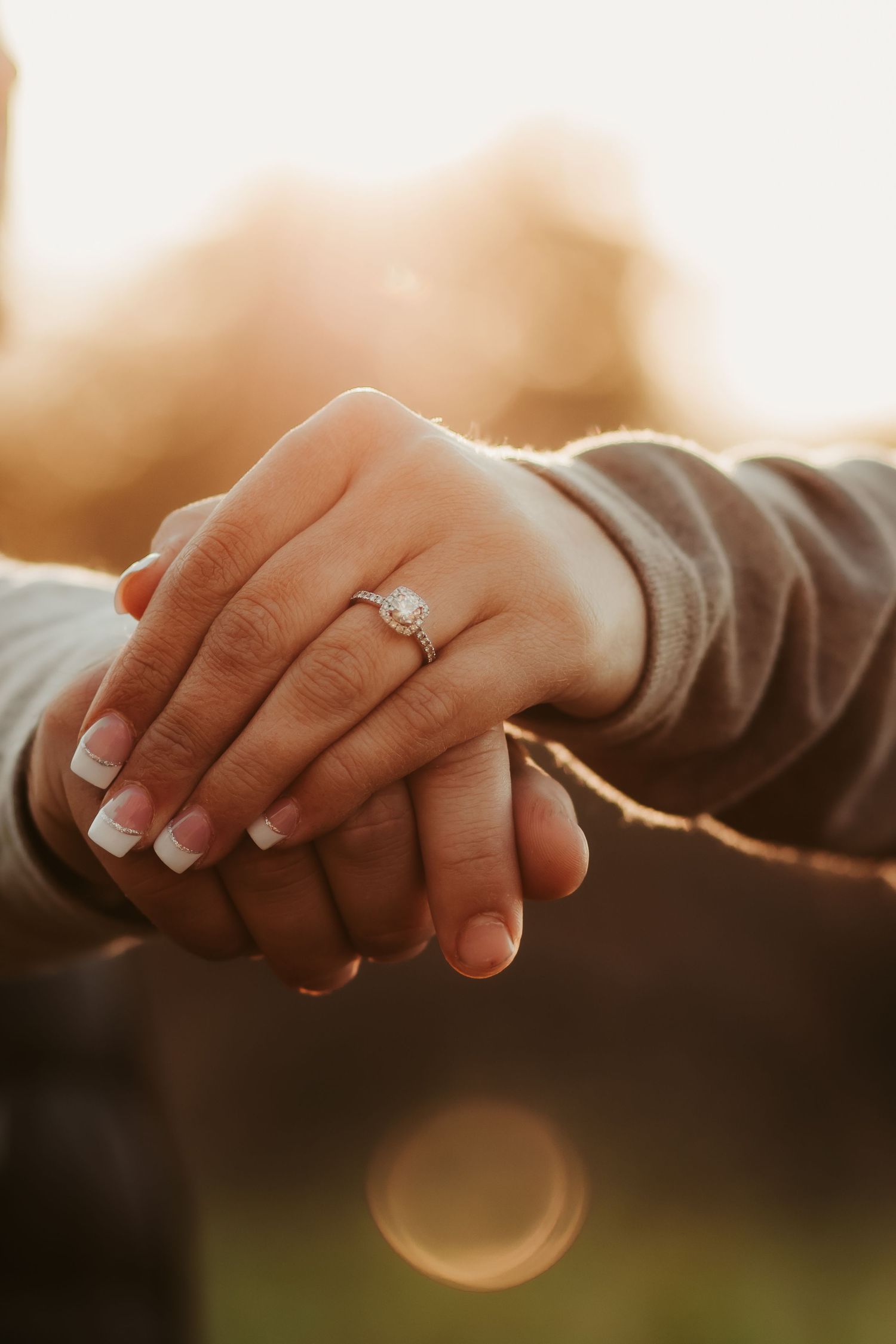 Close-up shots of hands with an engagement ring against a warm sunset background.