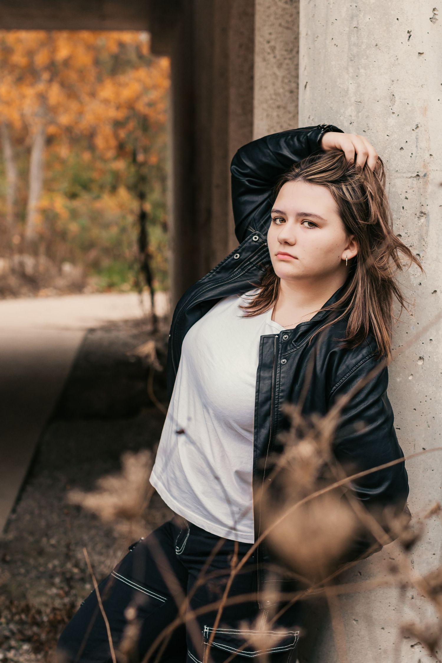 Fashion portraits against concrete pillars with dramatic autumn lighting.