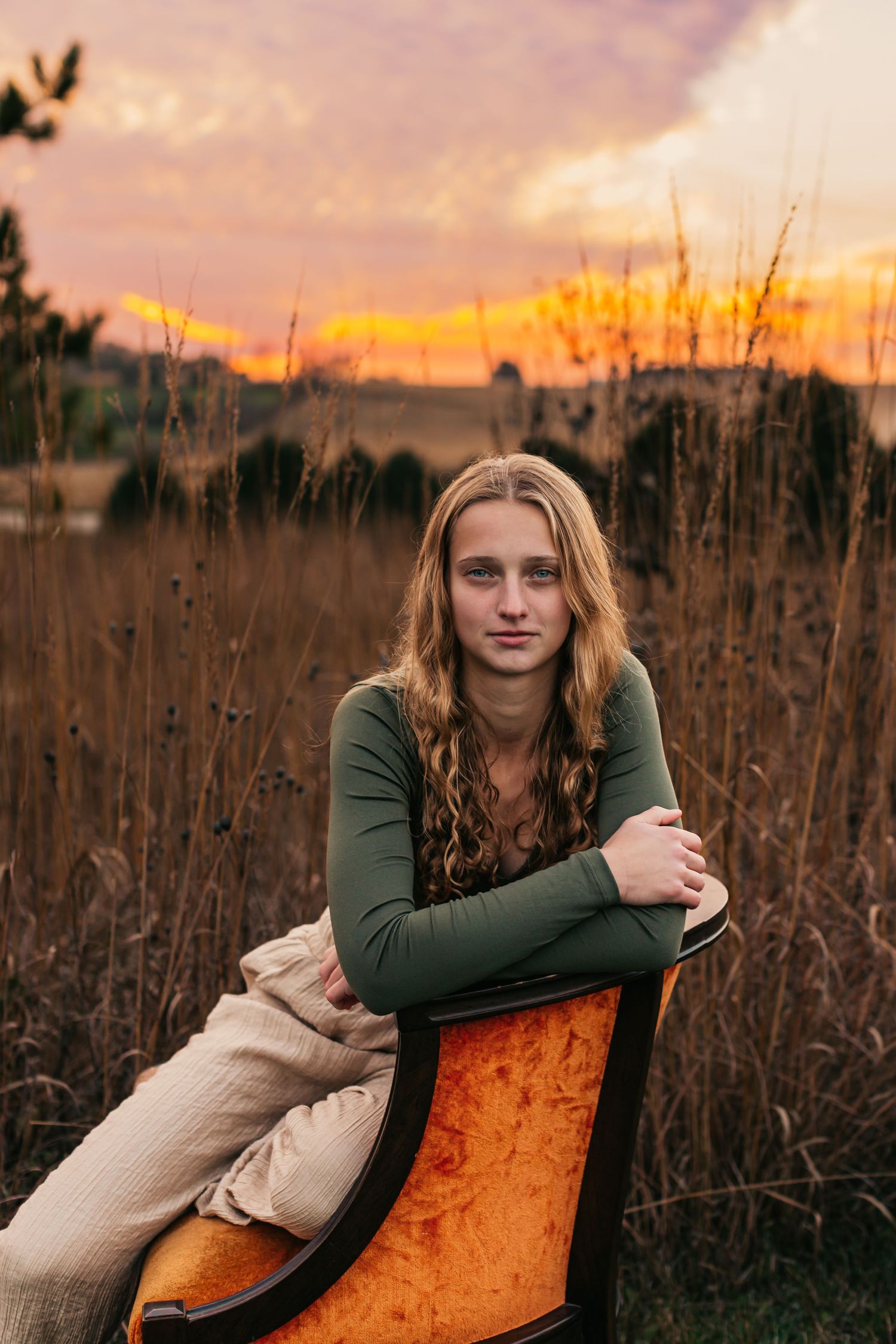 Portrait series at sunset with orange sky and dried field backdrop.