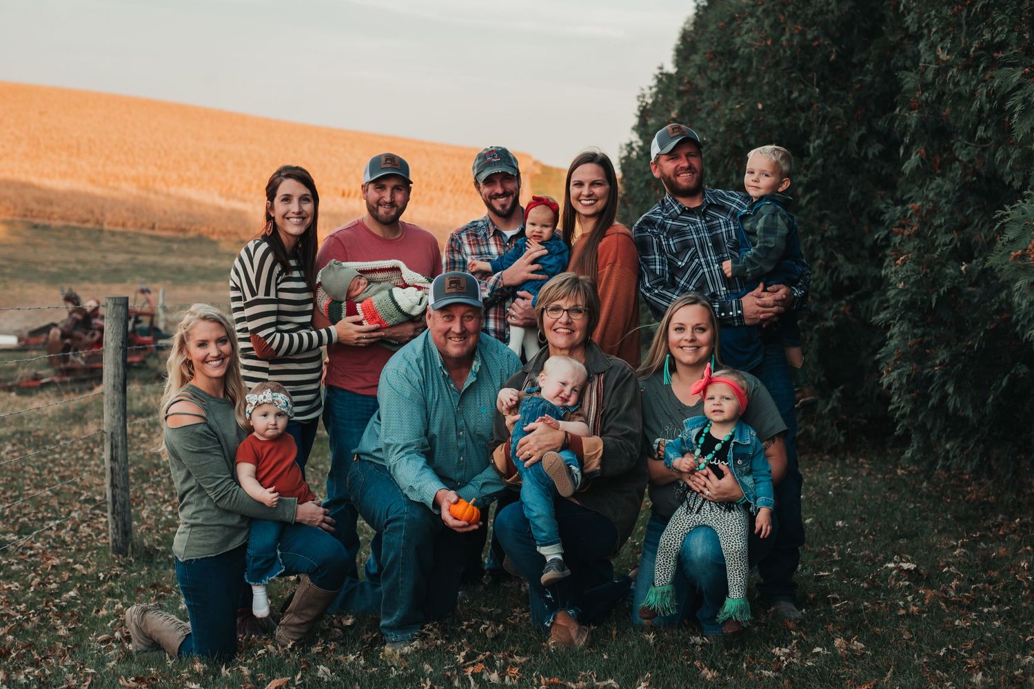Large family group poses together outdoors for a casual autumn portrait session.