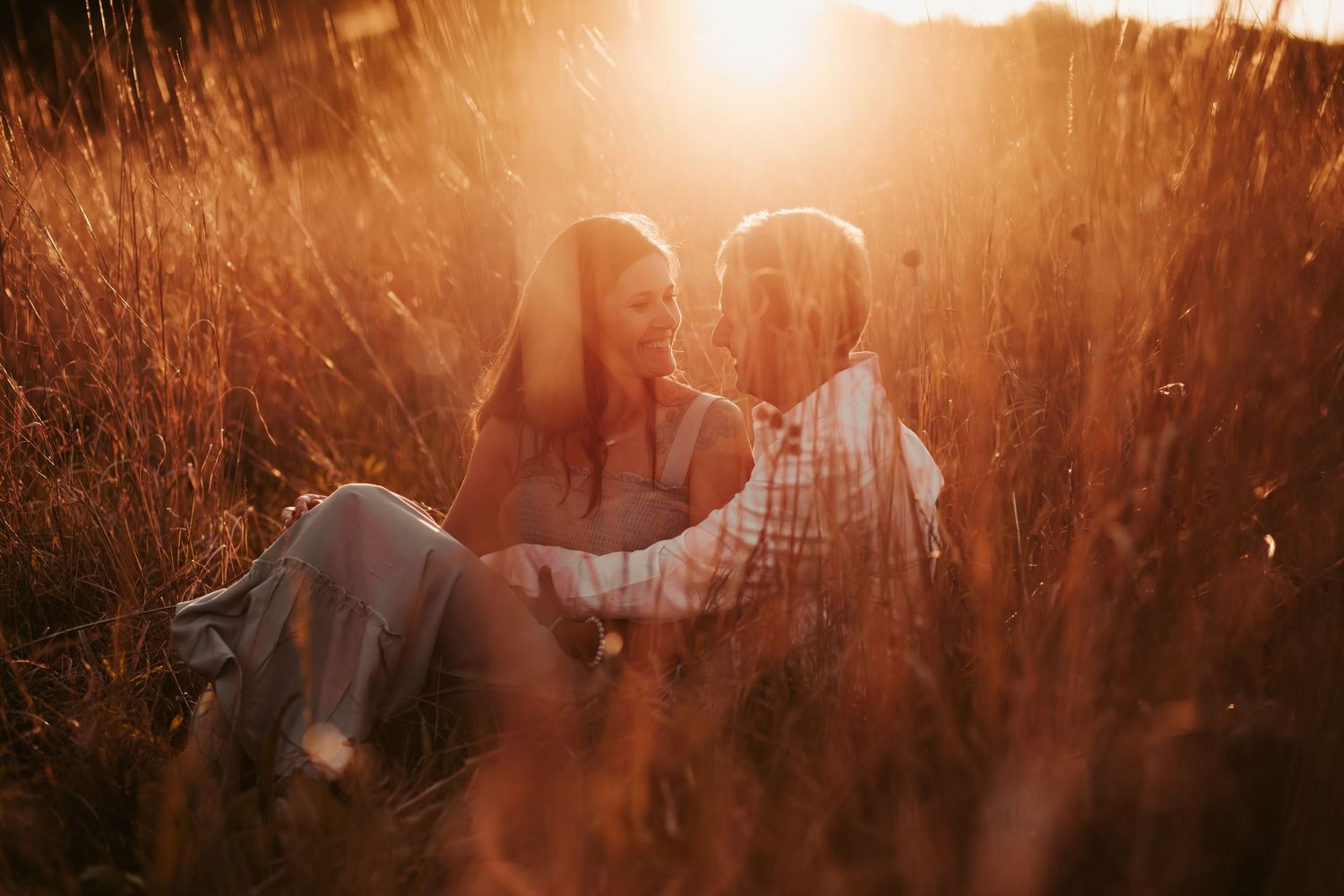 Dreamy sunset photography through tall grass with golden light.