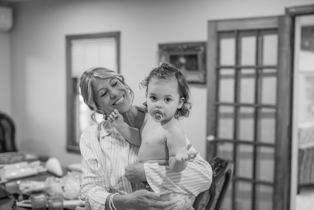 Black and white candid photos show joyful interactions between an adult and child in a casual indoor setting.
