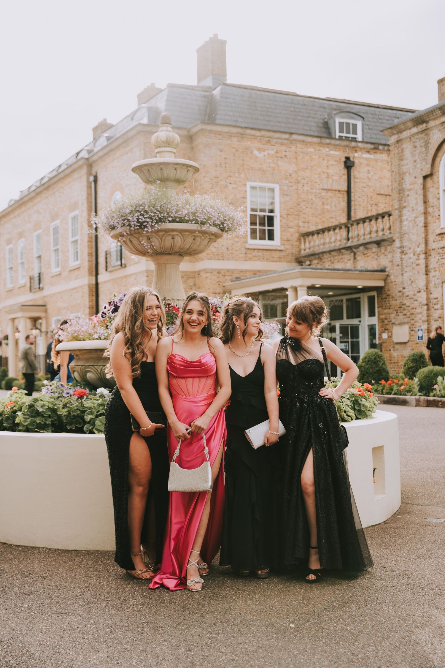 A group in formal attire gathers outside a historic stone building during a special occasion.