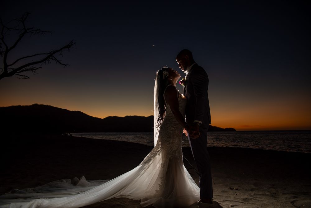 Wedding couple shares intimate moment against desert mountains during golden hour.
