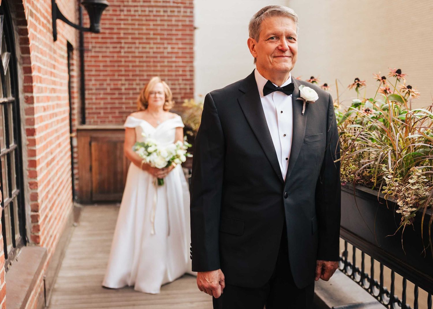 Father of the bride waiting for first look at Lenox Hotel Boston with bride approaching in the background