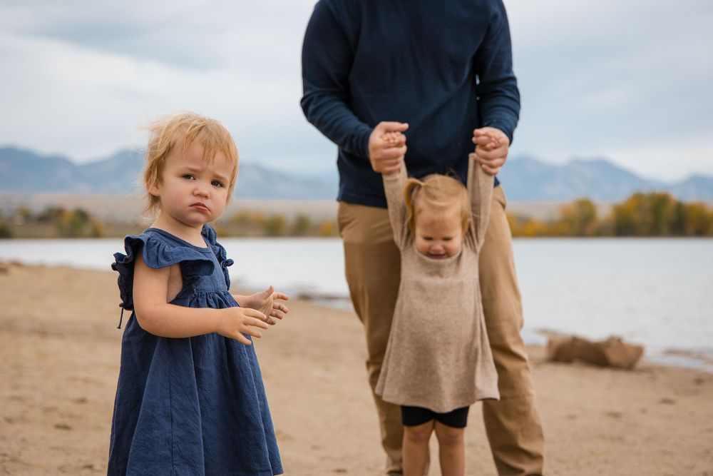 A series of candid beach photos showing a toddler in navy blue dress walking with someone in khaki pants.