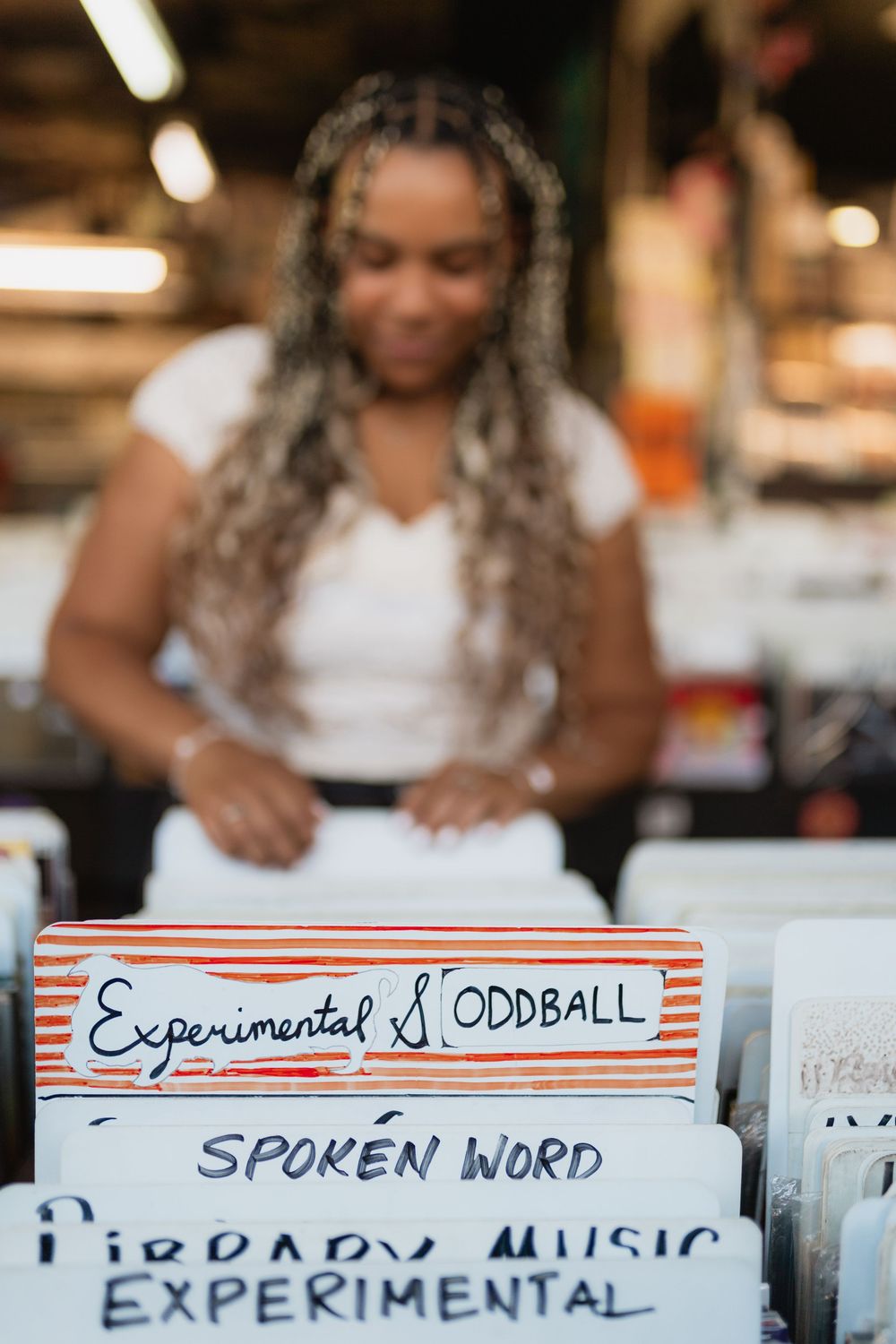 Close-up of labeled divider cards in a record store browsing section with text reading 'Experimental' visible.