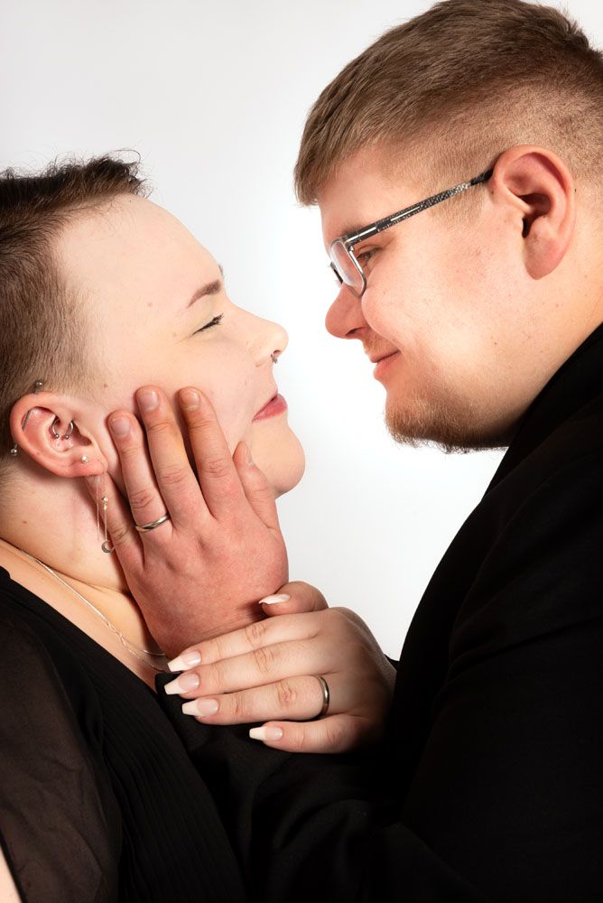 Studiossa valkoisella taustalla otettu lähikuva pariskunnasta. Mies pitää naisen poskesta hellästi kiinni ja pari katsoo toisiaan lempeästi.