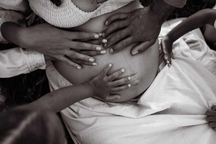 Manchester family photographer. Close-up view of hands holding and examining a white paper document against a light background.