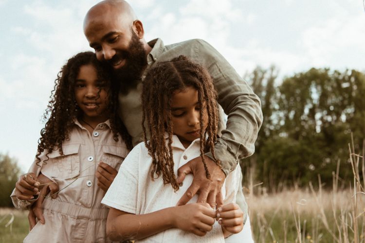 A tender embrace captured in warm sunlight showing closeness and intimacy between two people during a family photoshoot in Manchester.
