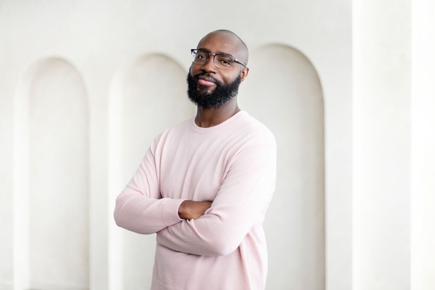 Person in pink sweater standing against white wall shown in multiple poses.