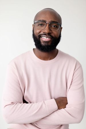 Four sequential shots of a person wearing glasses and a pink sweater showing different expressions and poses.