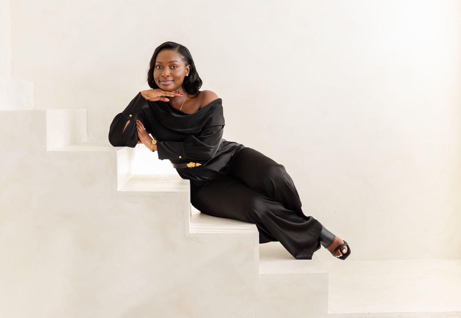 A person in a black sweater strikes dynamic poses against a white background in a photo series.