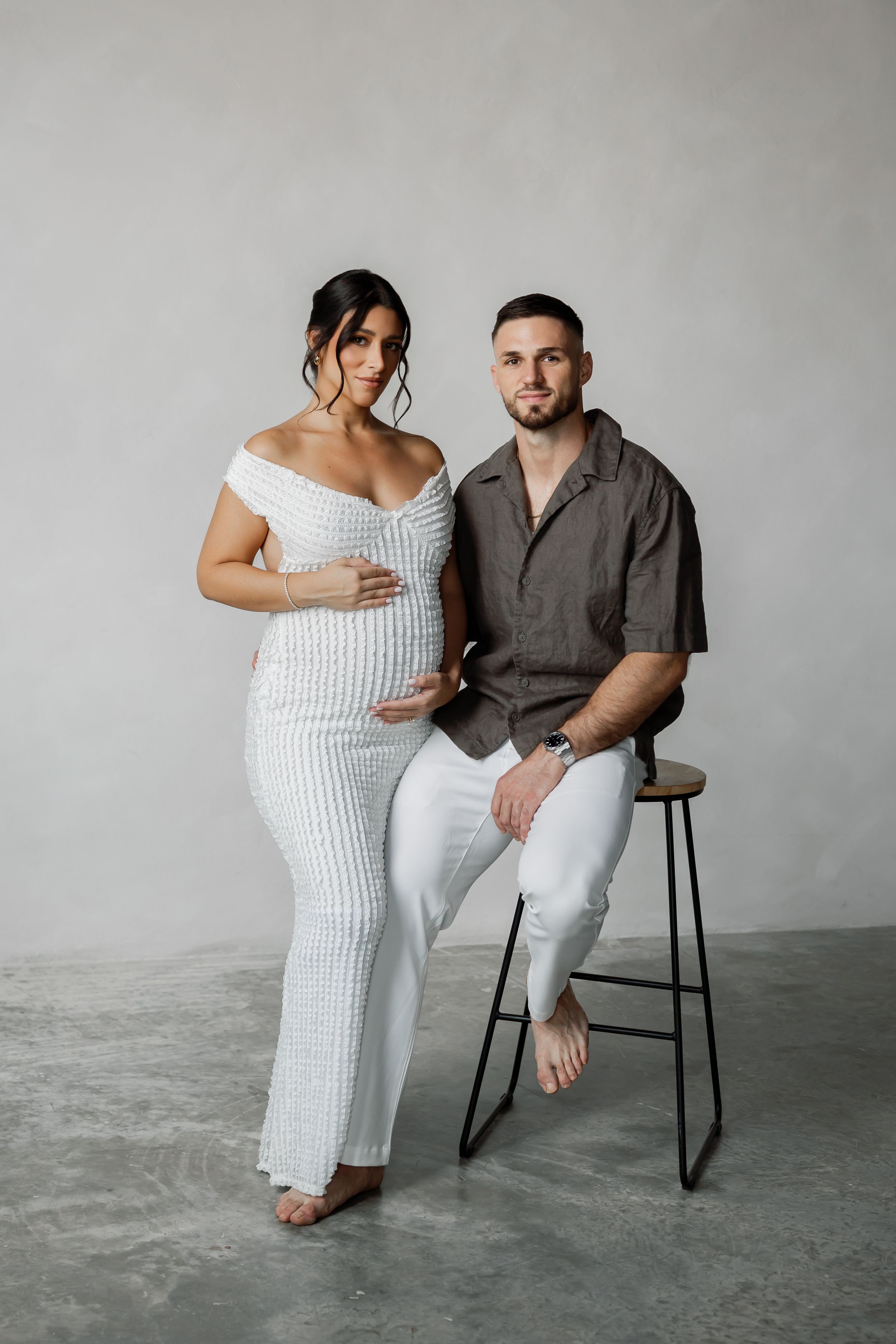A couple standing together in a studio setting.