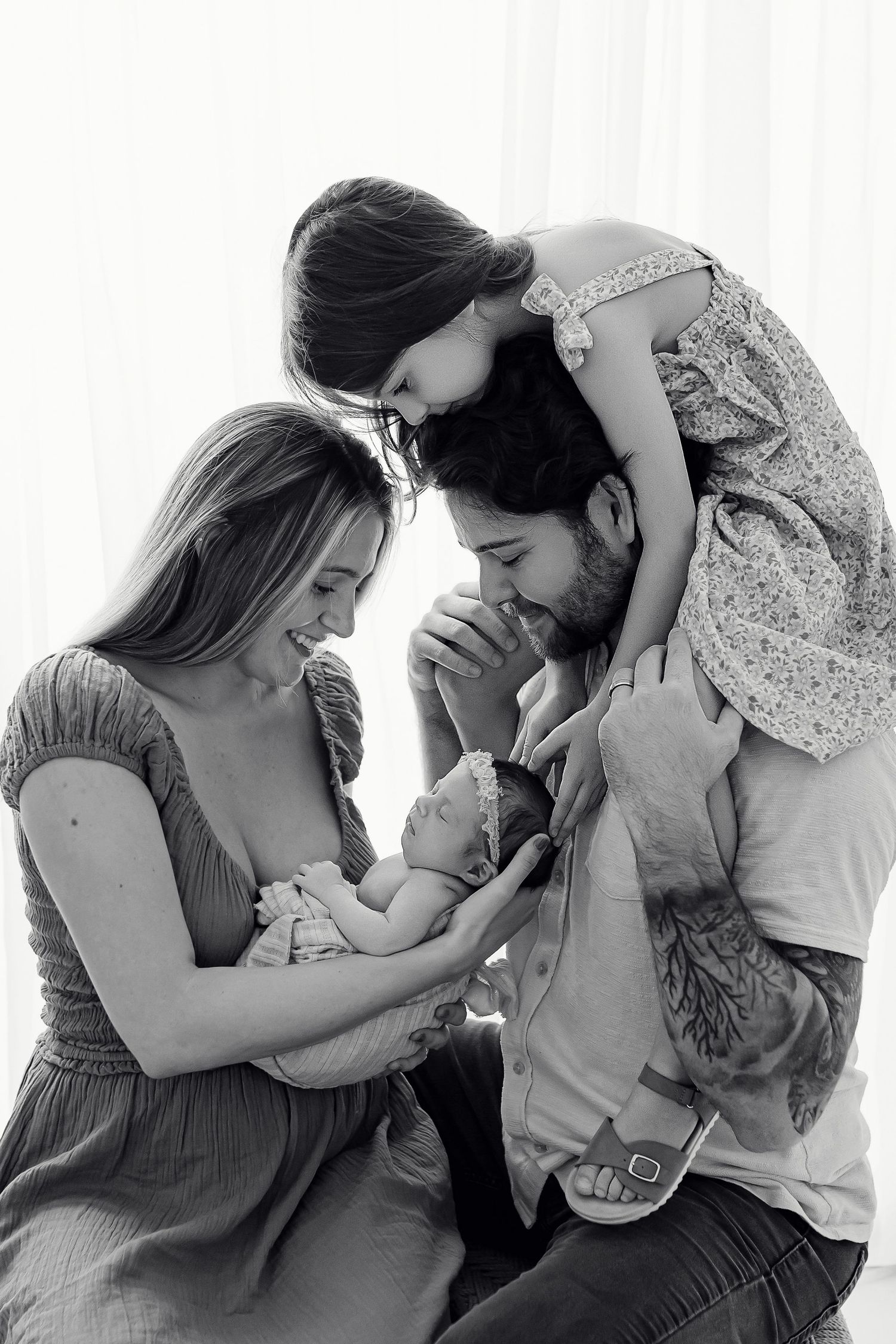 Family with big sister and newborn baby during black and white studio session at Flowertown Photography