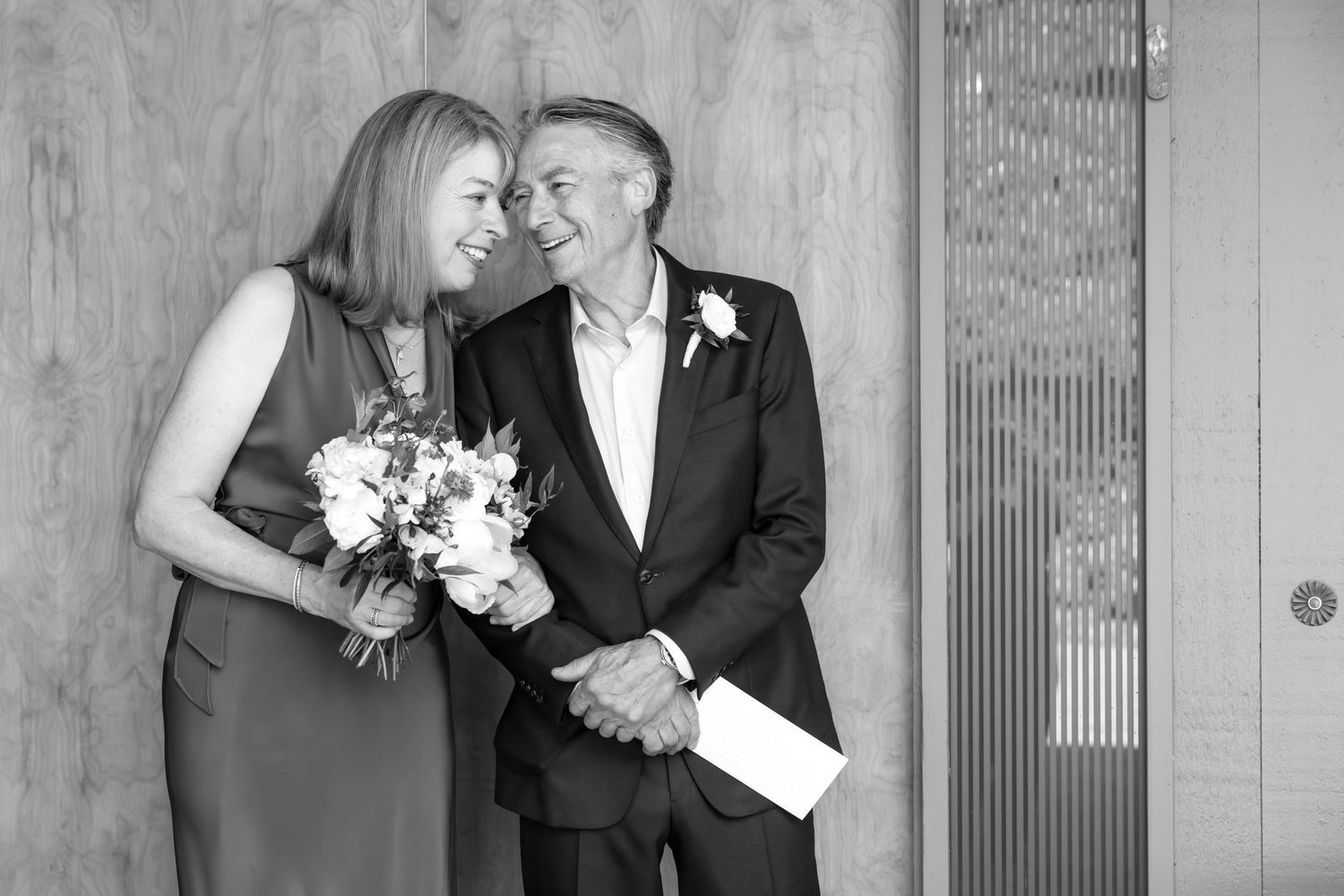 Black and white wedding photos showing romantic moments between a couple with flowers and formal attire.
