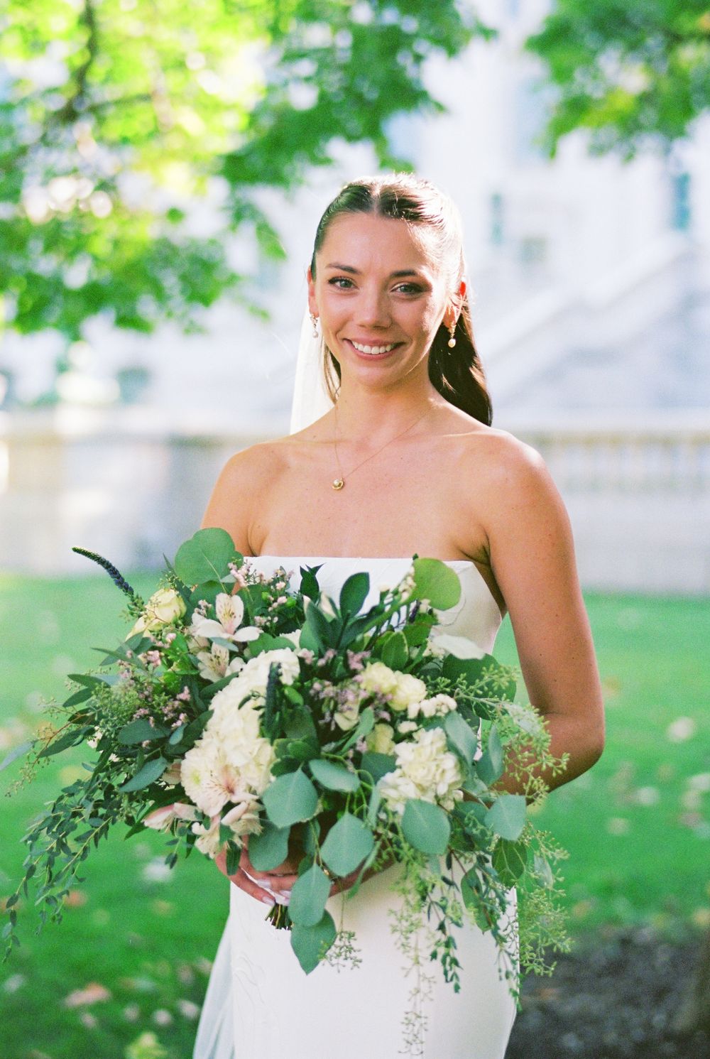 Close-up shots of an elegant bridal bouquet with white flowers and cascading greenery.