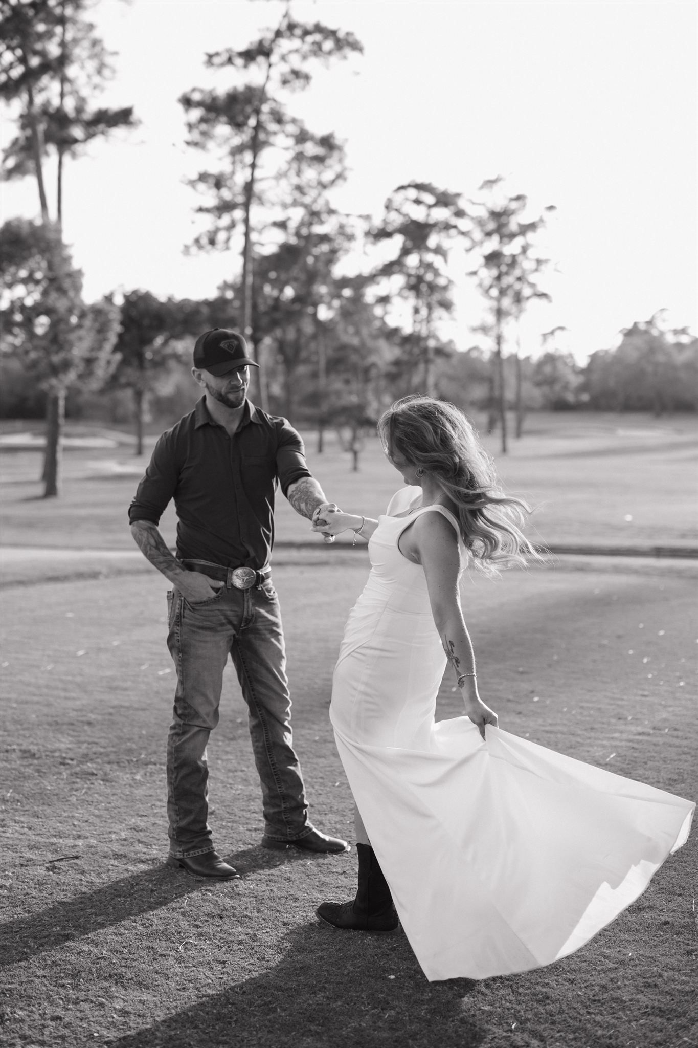 A romantic black and white photo sequence of a couple dancing playfully on a golf course.