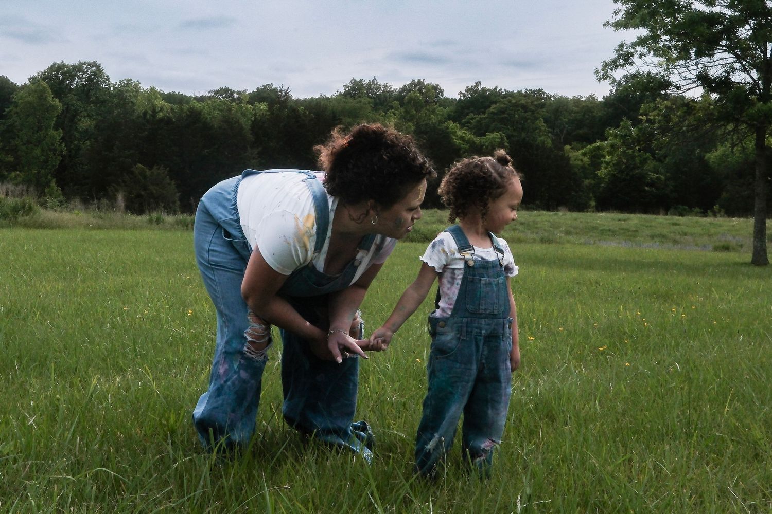 Family members walking together through a green meadow.