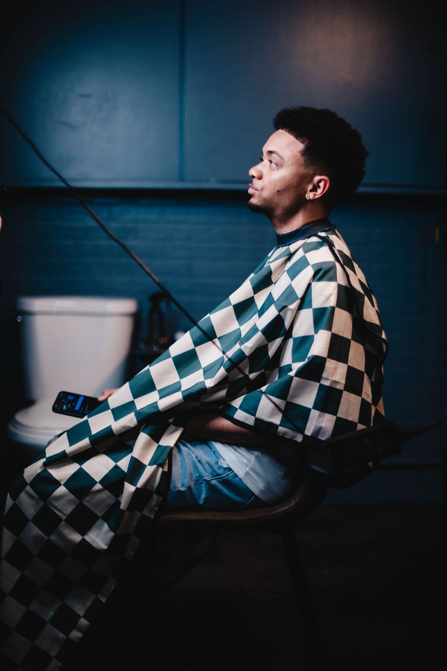 Person in black and white checkered jacket shown in dynamic side profiles against dark background.