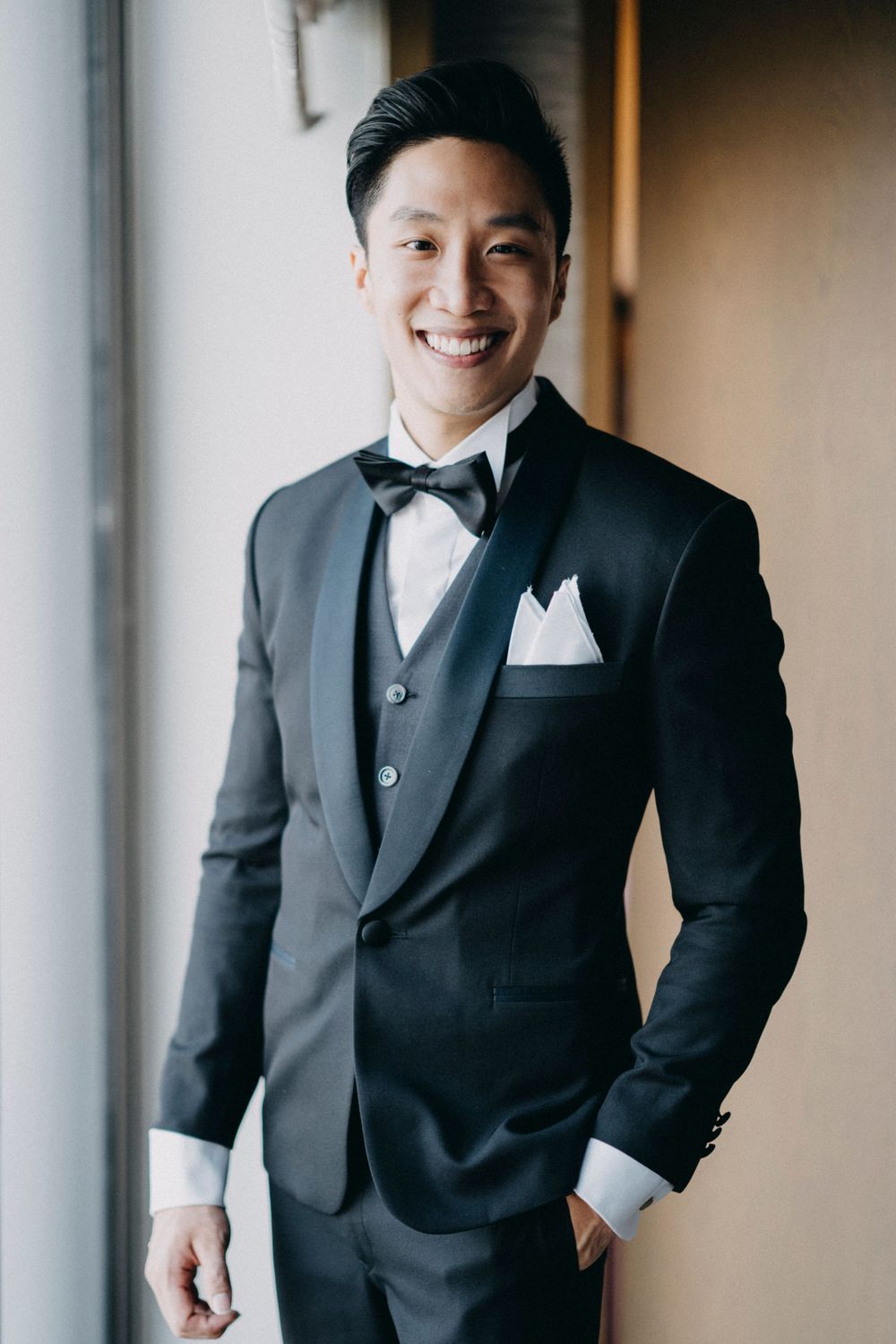 Classic formal portrait showing black tuxedo with bow tie and white pocket square.