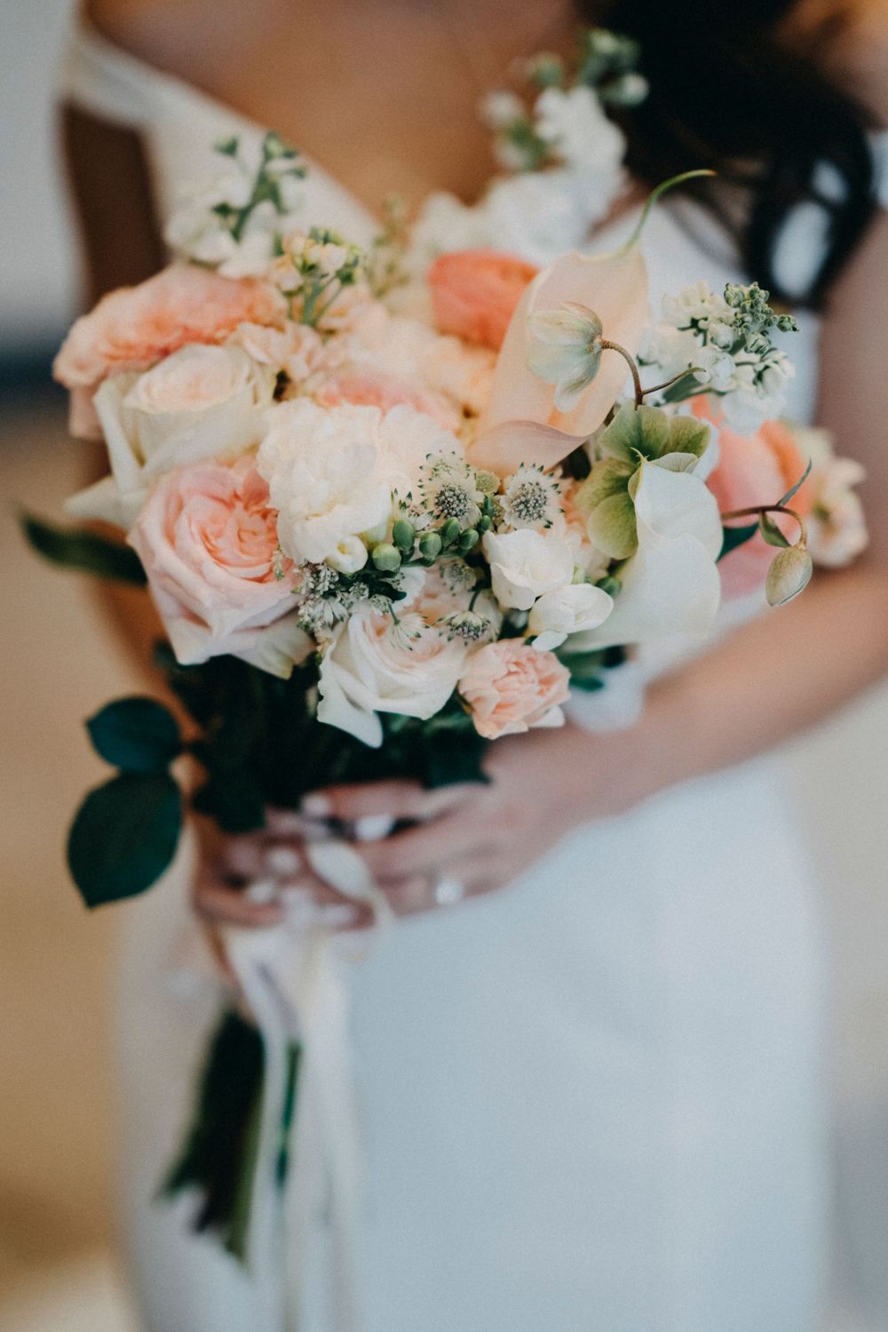 Elegant pale pink and white wedding bouquets with roses and delicate greenery accents.