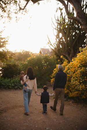 fall vibes a family of four walking towards the sunset