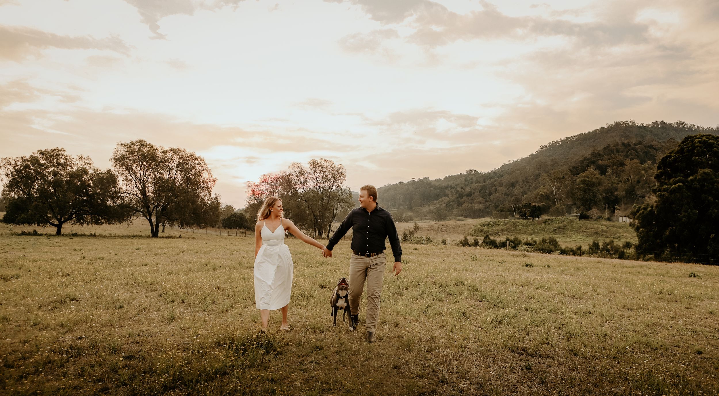A panoramic collage of five outdoor wedding photos showing scenic mountain and field landscapes at sunset.