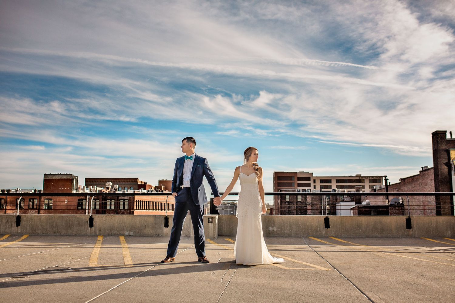 A panoramic sequence showing a couple in wedding attire on a rooftop with an urban skyline background under blue skies.