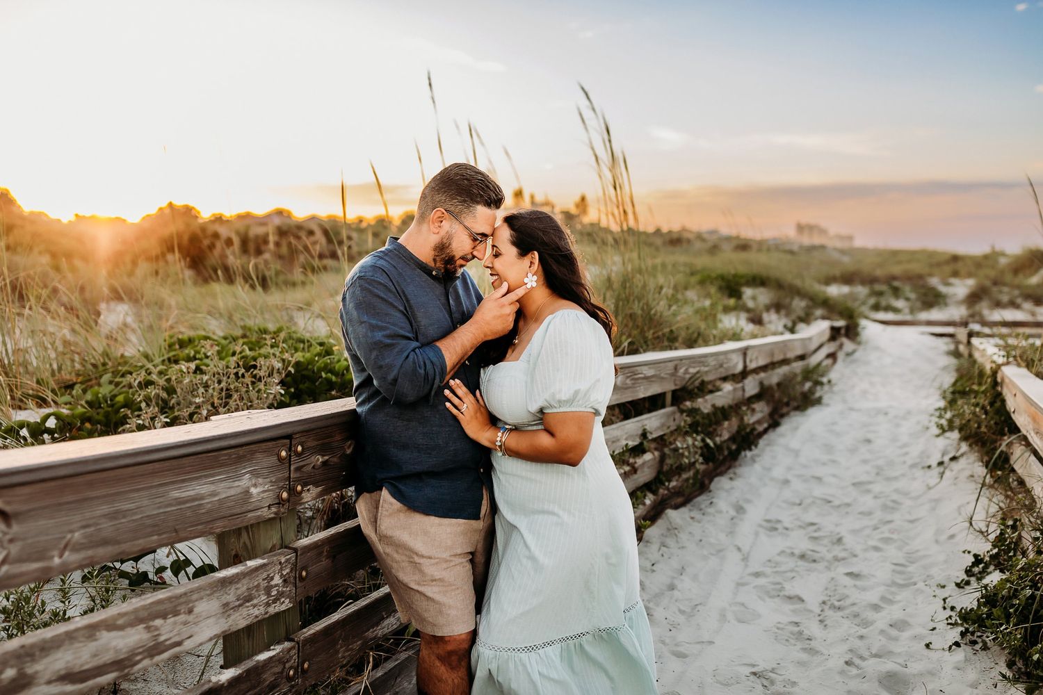 A romantic coastal beach photoshoot at sunset with a beach walkway and ocean views in the background.