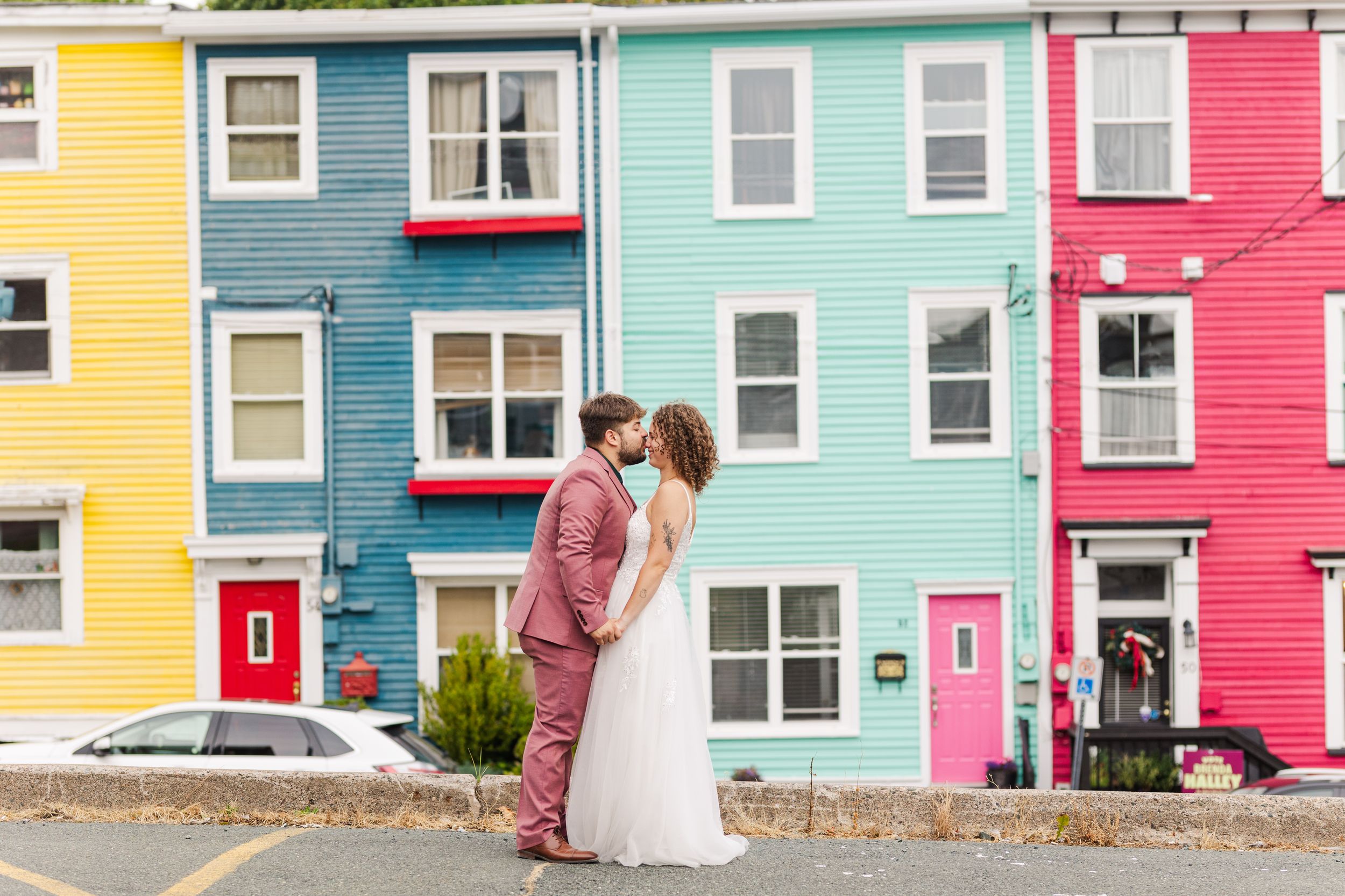 Row of colorful houses in bright yellow, turquoise and pink along the street in St. John's, Newfoundland.