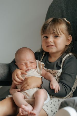 A series of tender moments with a tiny baby being held and cuddled in someone's arms.
