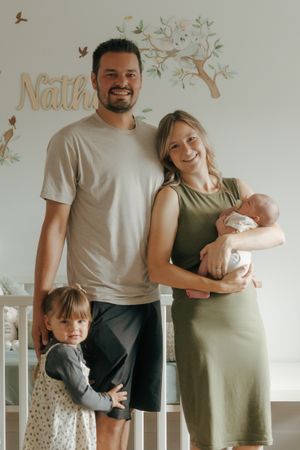 Family photoshoot sequence showing parents in casual outfits with a small child and newborn against a light wall.