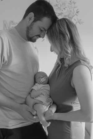 Black and white series showing tender moments between parents and their newborn baby.