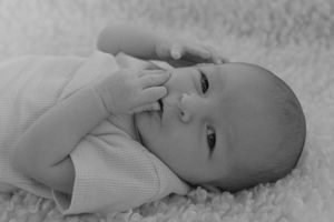 Closeup black and white portraits of a peaceful sleeping newborn baby lying on soft blankets.