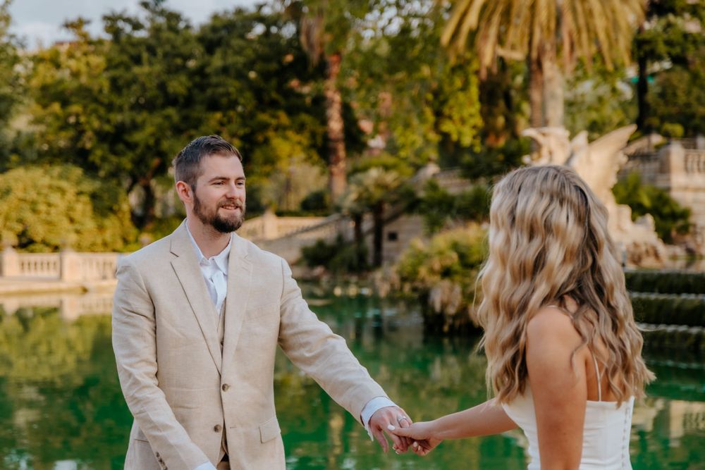 Candid joy captured as the couple walks past lush greenery.