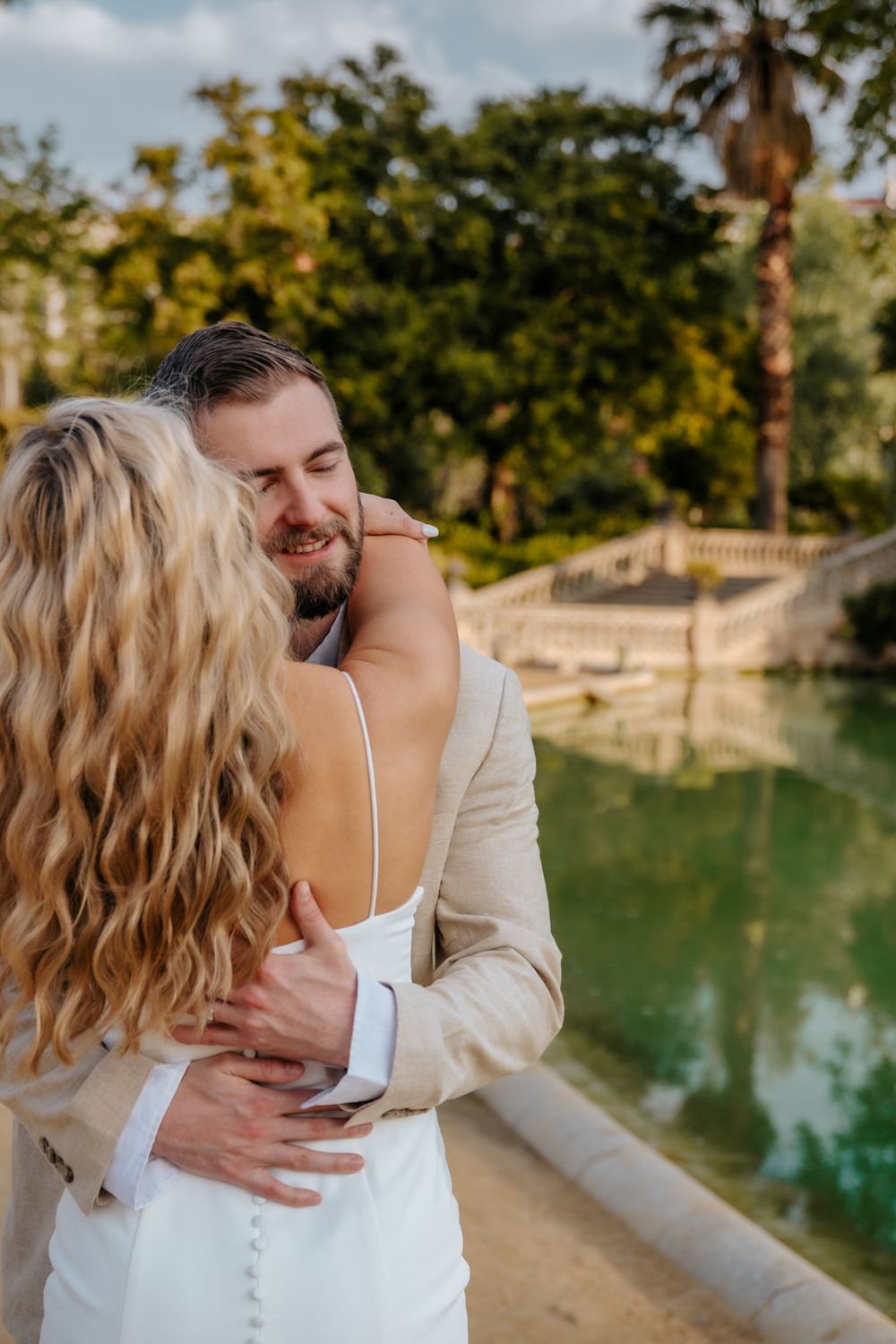 Couple sharing a sweet kiss under the morning sun in Ciutadella Park.