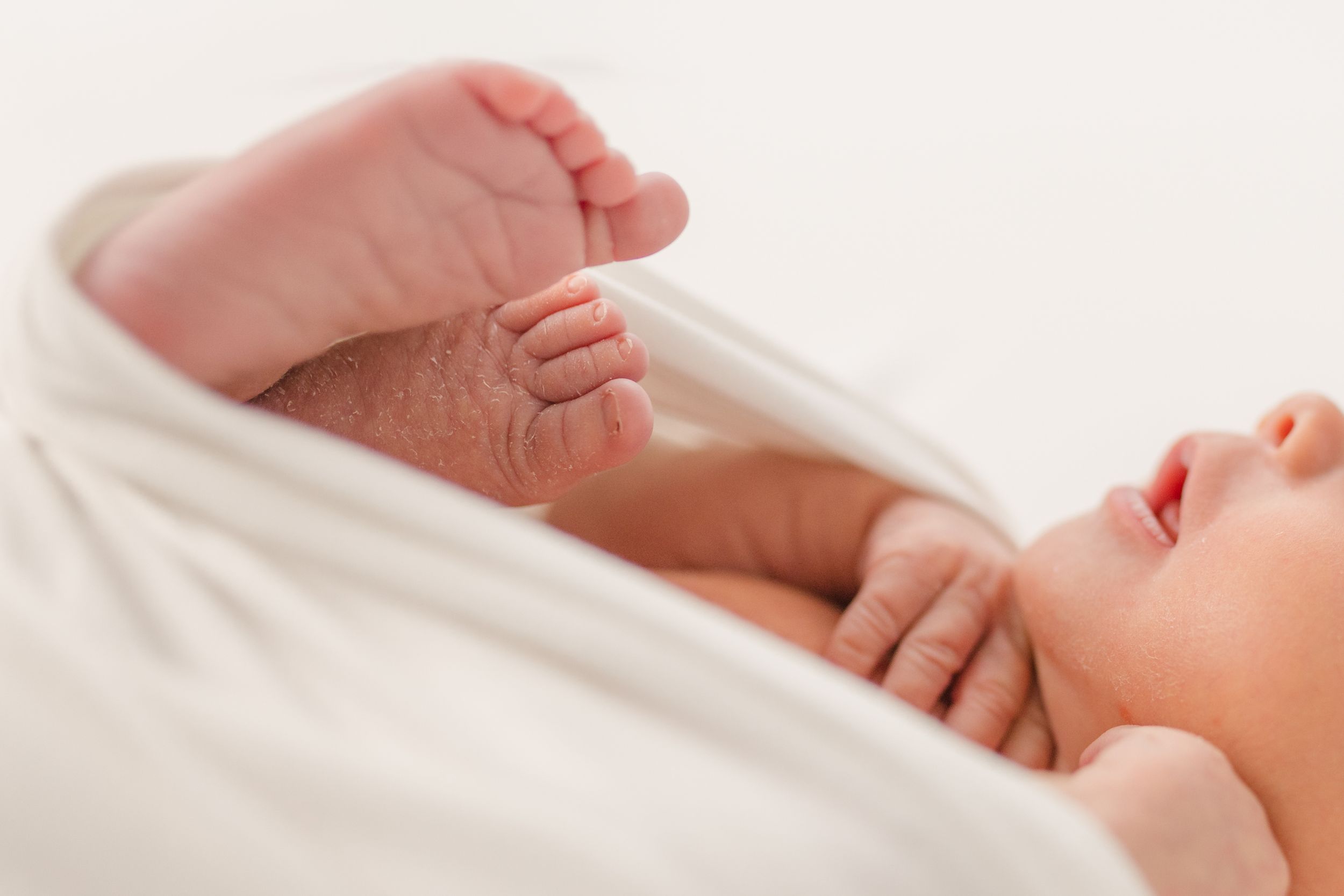 A close-up series of tiny baby feet and toes against a white background.