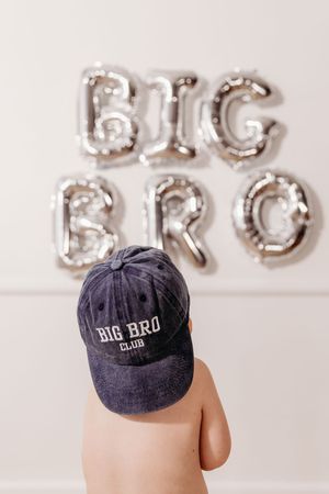 Navy blue baseball cap with 'Big Bro' text against silver balloon letters.