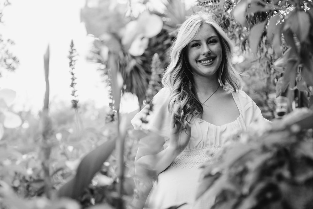 Black and white photo collage showing candid moments at an outdoor wedding celebration among trees and foliage.