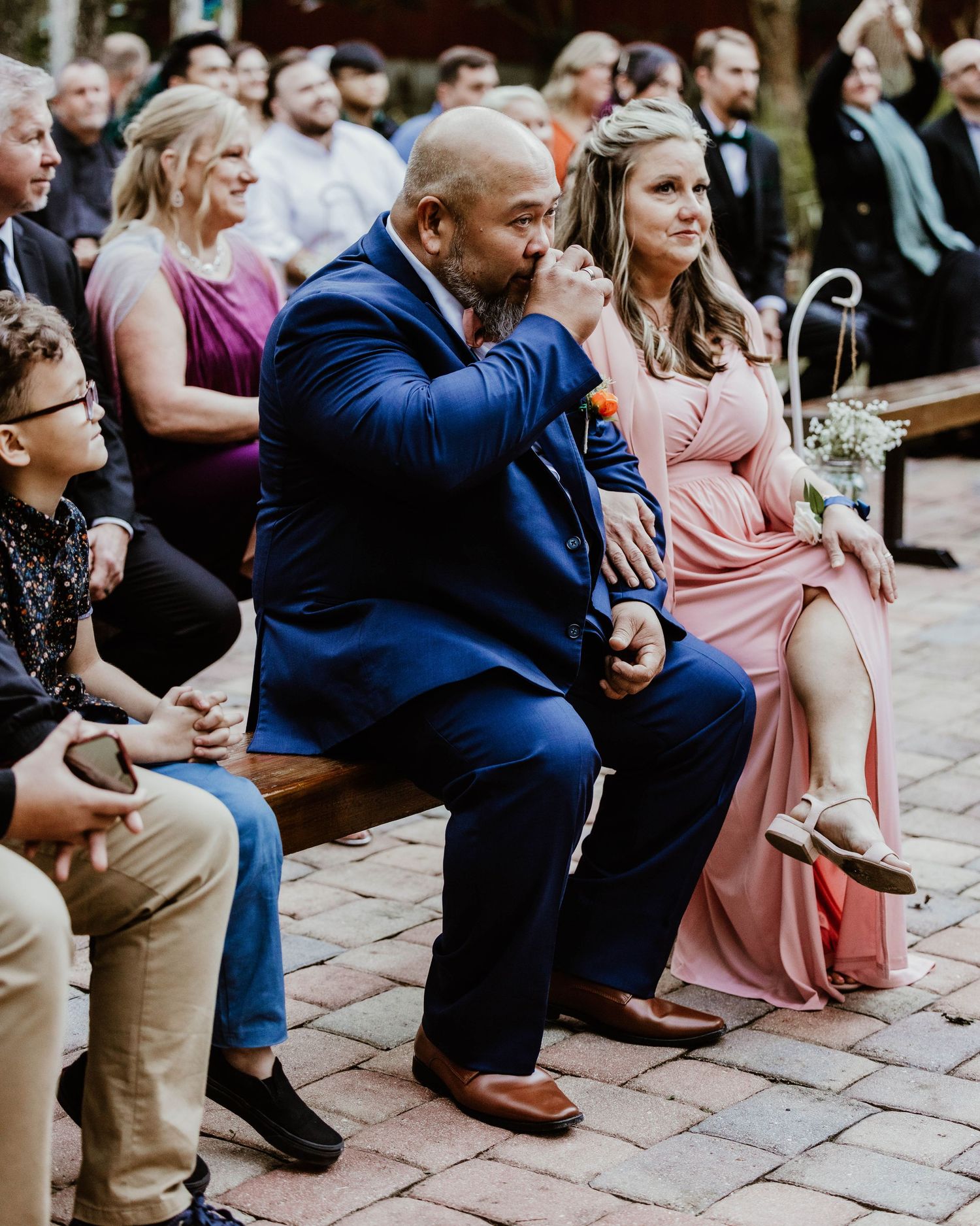 dad crying at an outdoor wedding ceremony watch the proceedings on a stone paved patio area.. Heirloom wedding photos Orlando