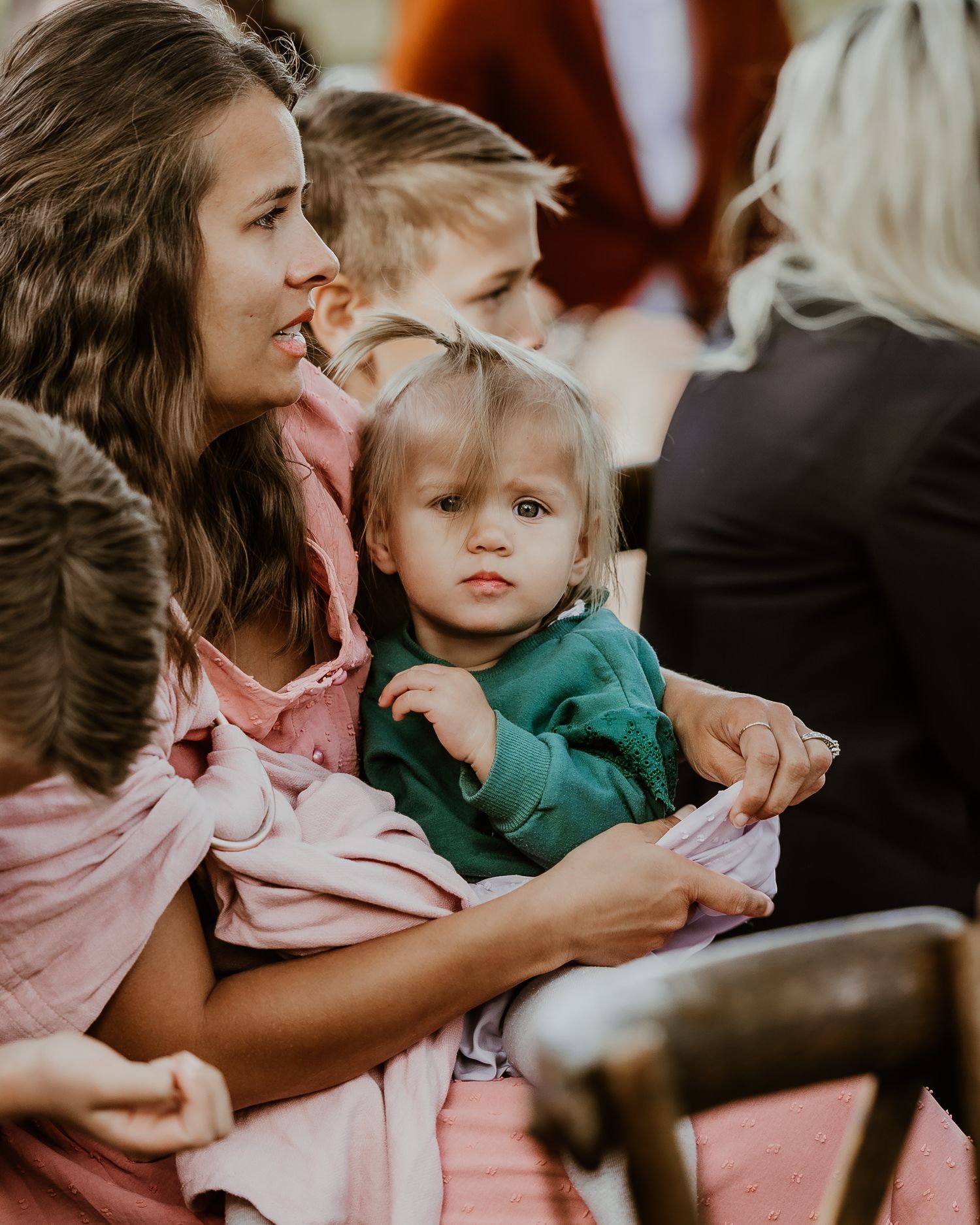 Close-up shot showing tender interaction in soft natural lighting between parent and child in casual attire. Candid wedding photographer