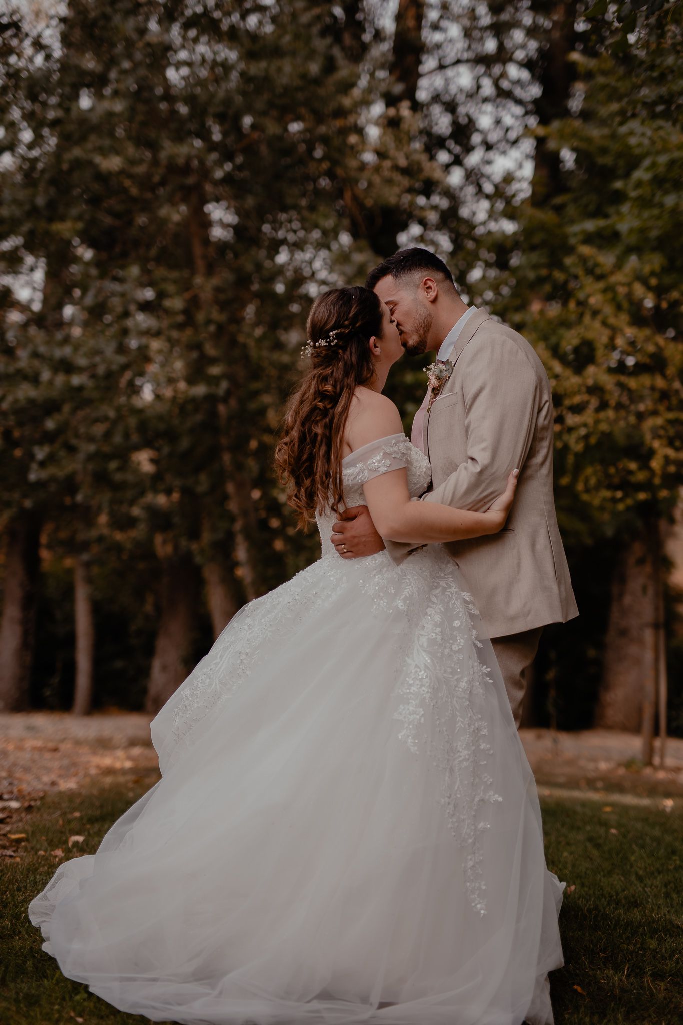 Romantic outdoor wedding moment captured in a wooded garden setting.