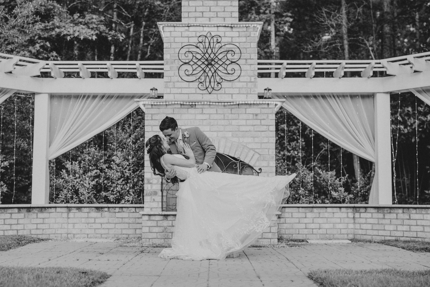 A horizontal sequence of black and white wedding photos against a white brick and metal outdoor backdrop.