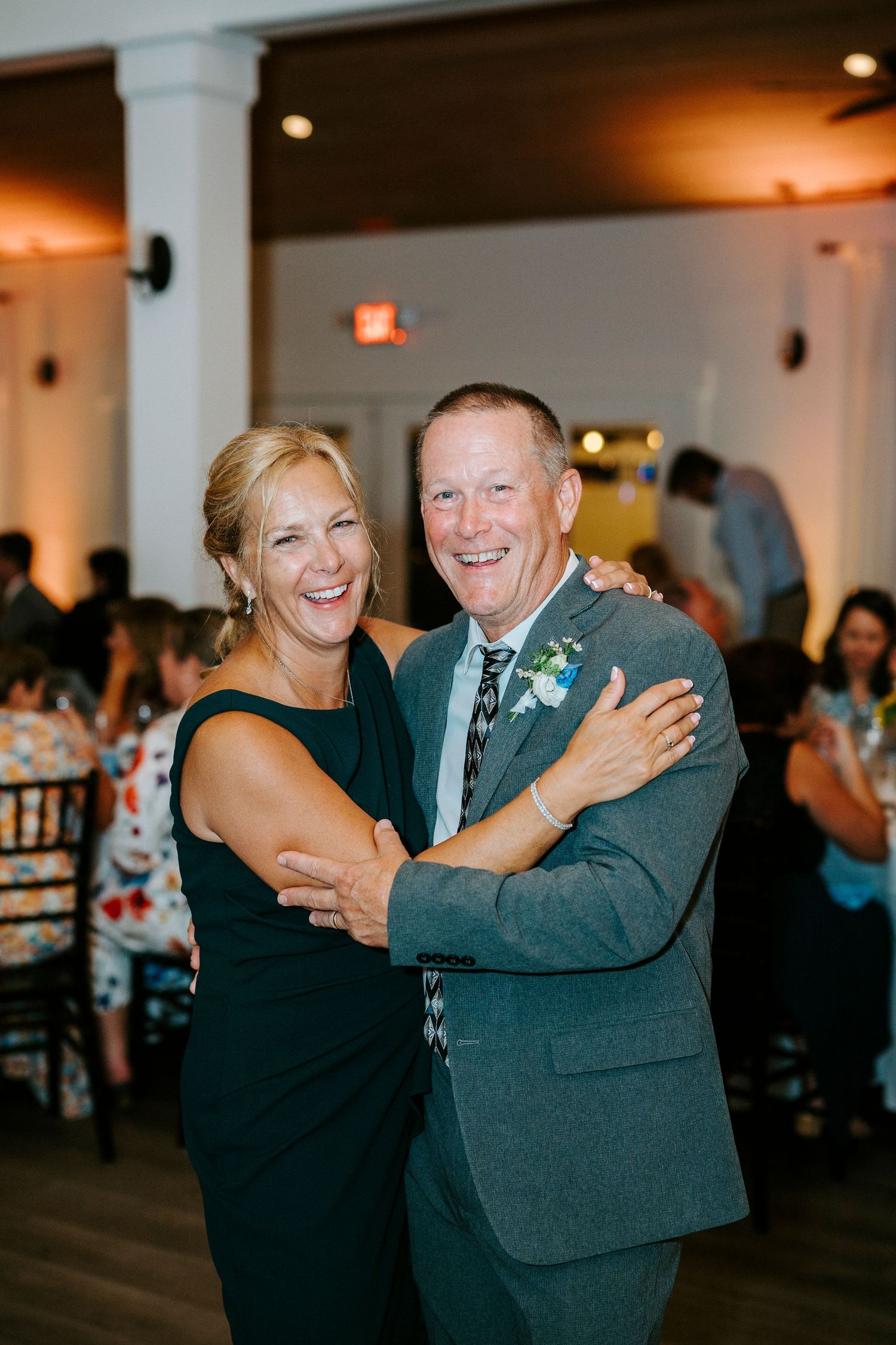 A couple shares a joyful dance moment at a wedding reception in an elegant venue.