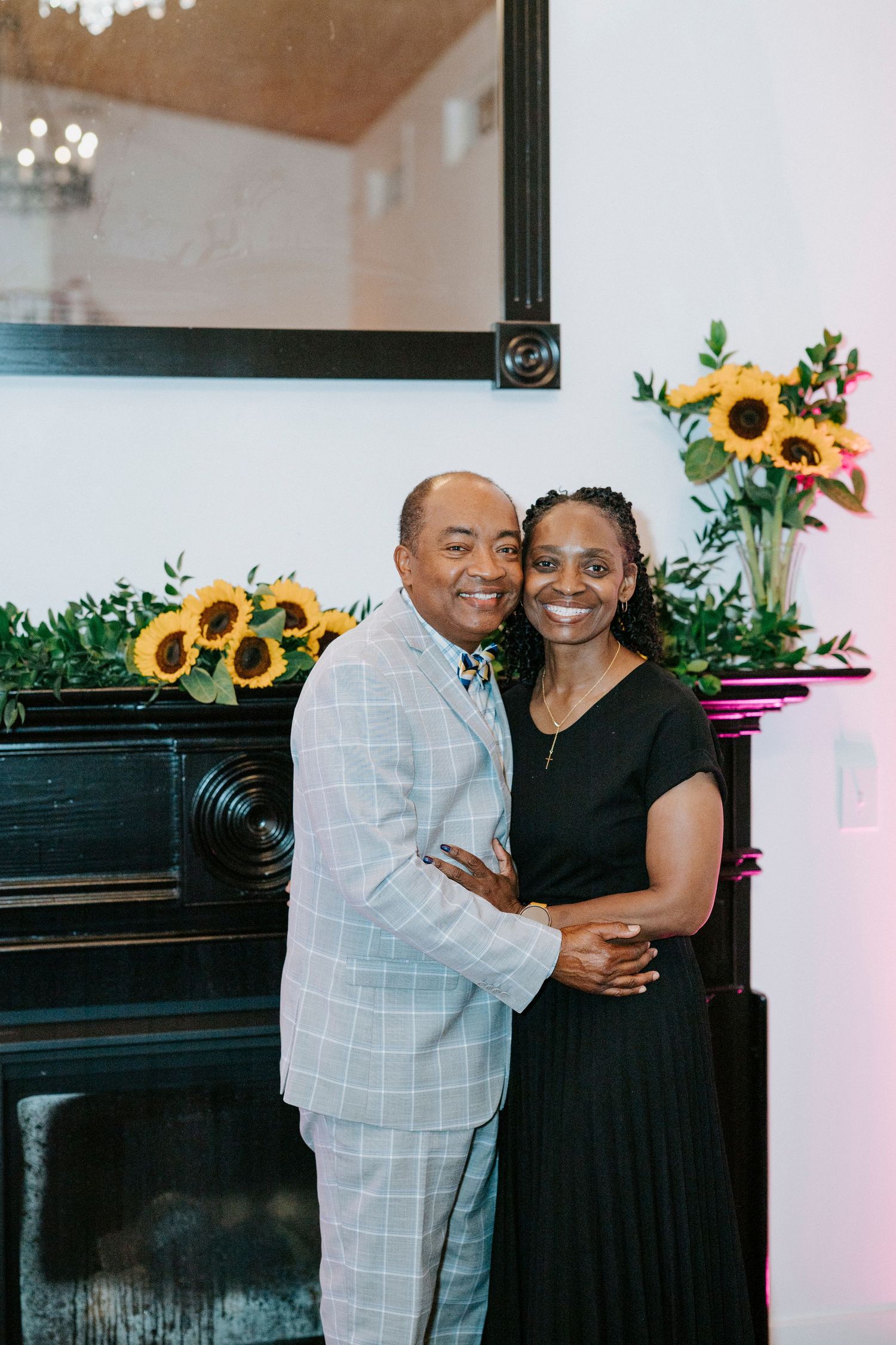 Wedding reception space decorated with cheerful sunflower arrangements and a piano in the background.