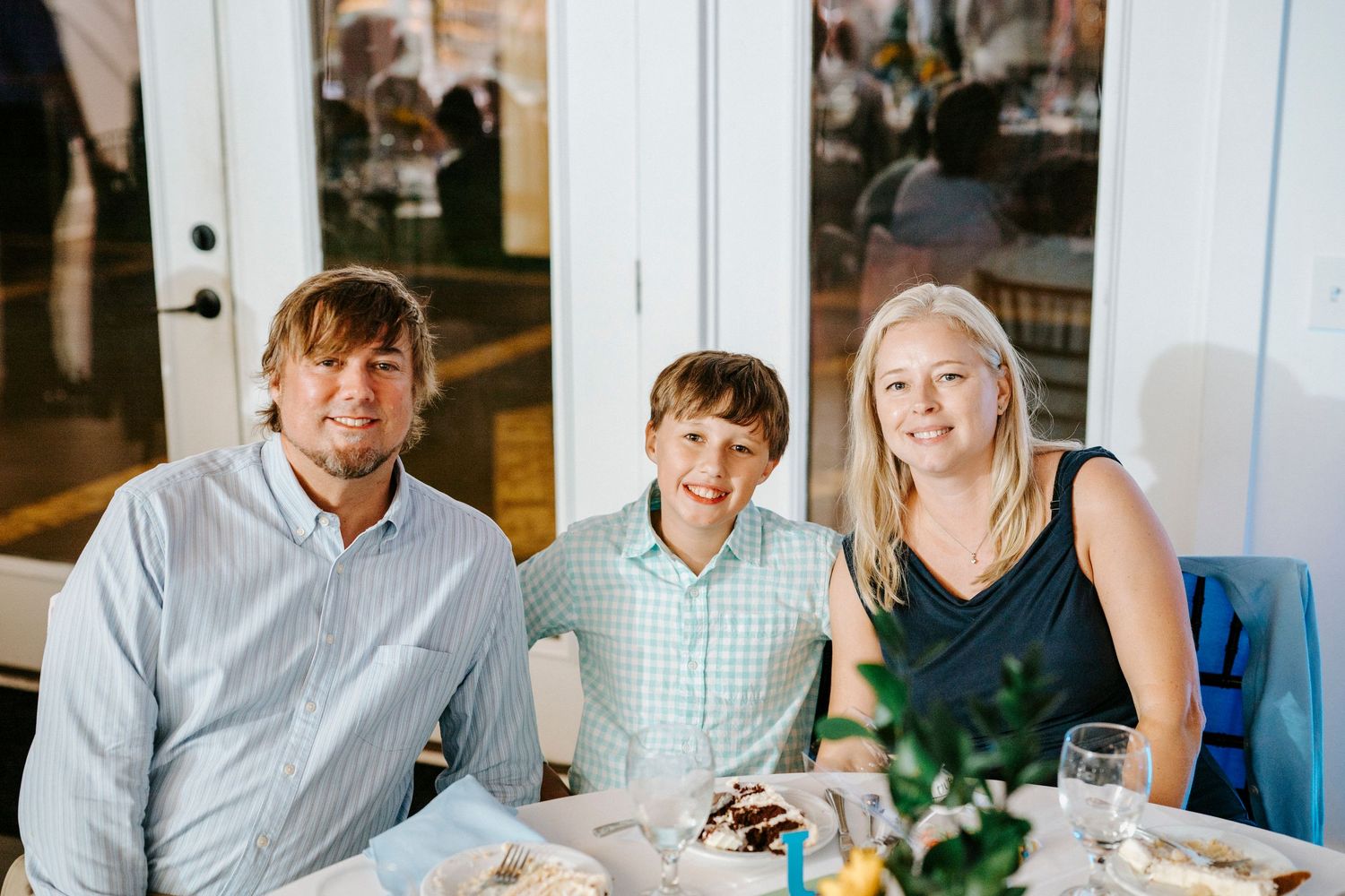 Family members gather around tables in a restaurant for a celebratory meal together.