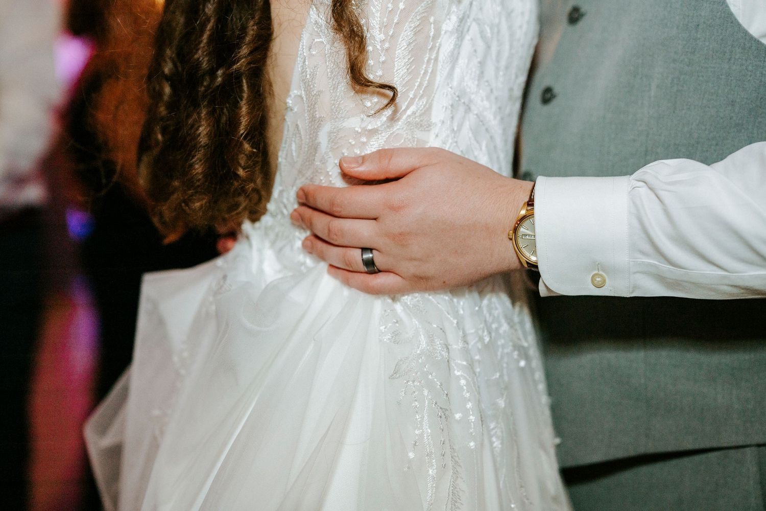 Close-up shot of elegant white wedding dress details with sparkly embellishments.